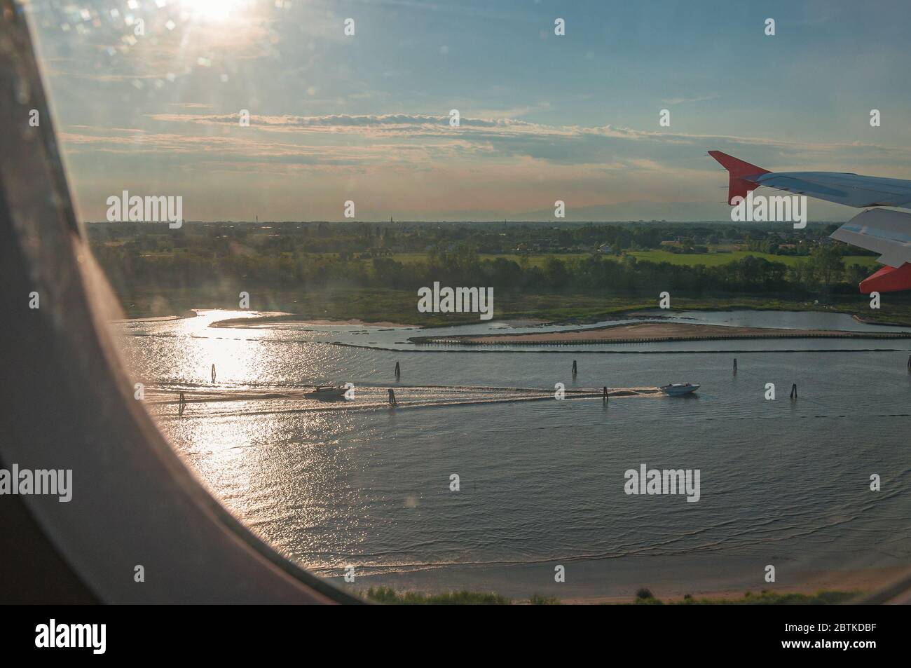View of boat sailing in the Venice lagoon from an airliner porthole, Italy. Concept: air travel, aerial panoramas Stock Photo