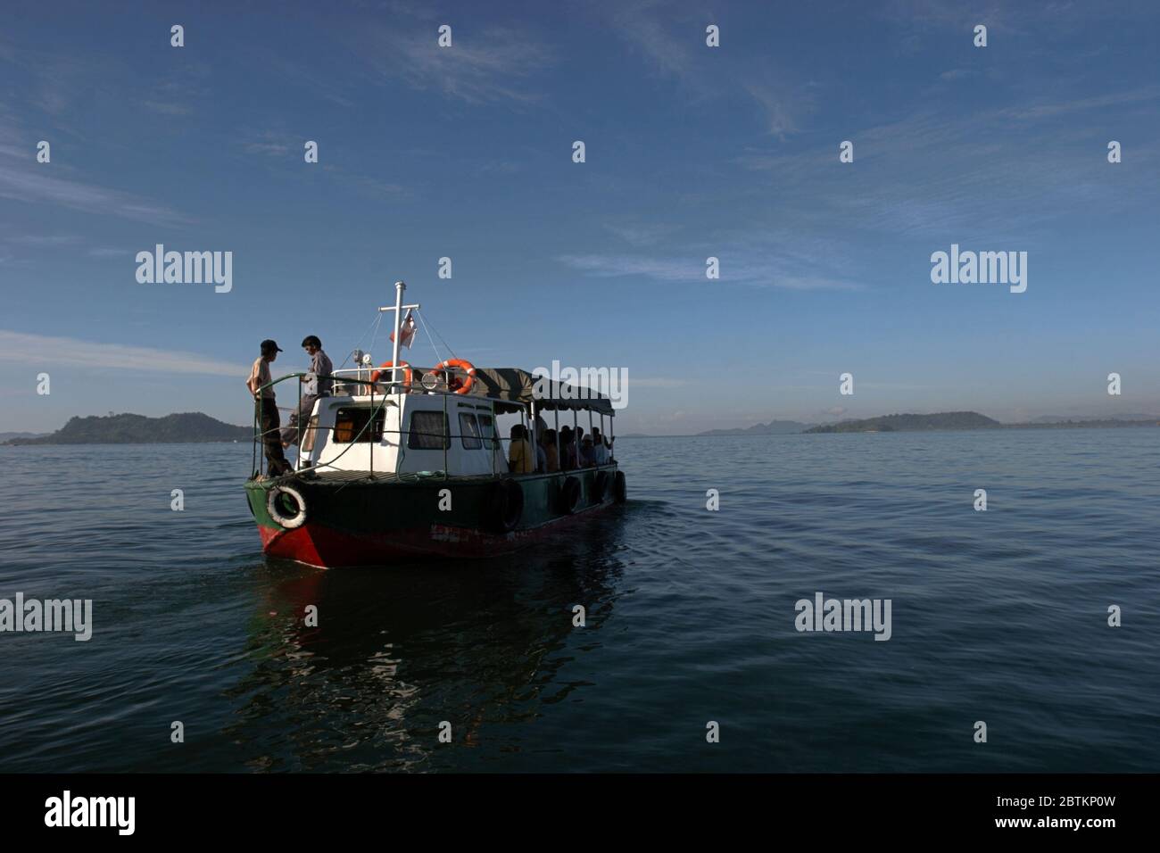 A small ferry boat transporting passengers to neighboring villages in Sibolga Bay from Sibolga City. Sibolga, North Sumatra, Indonesia. Archival photo (2005). Stock Photo