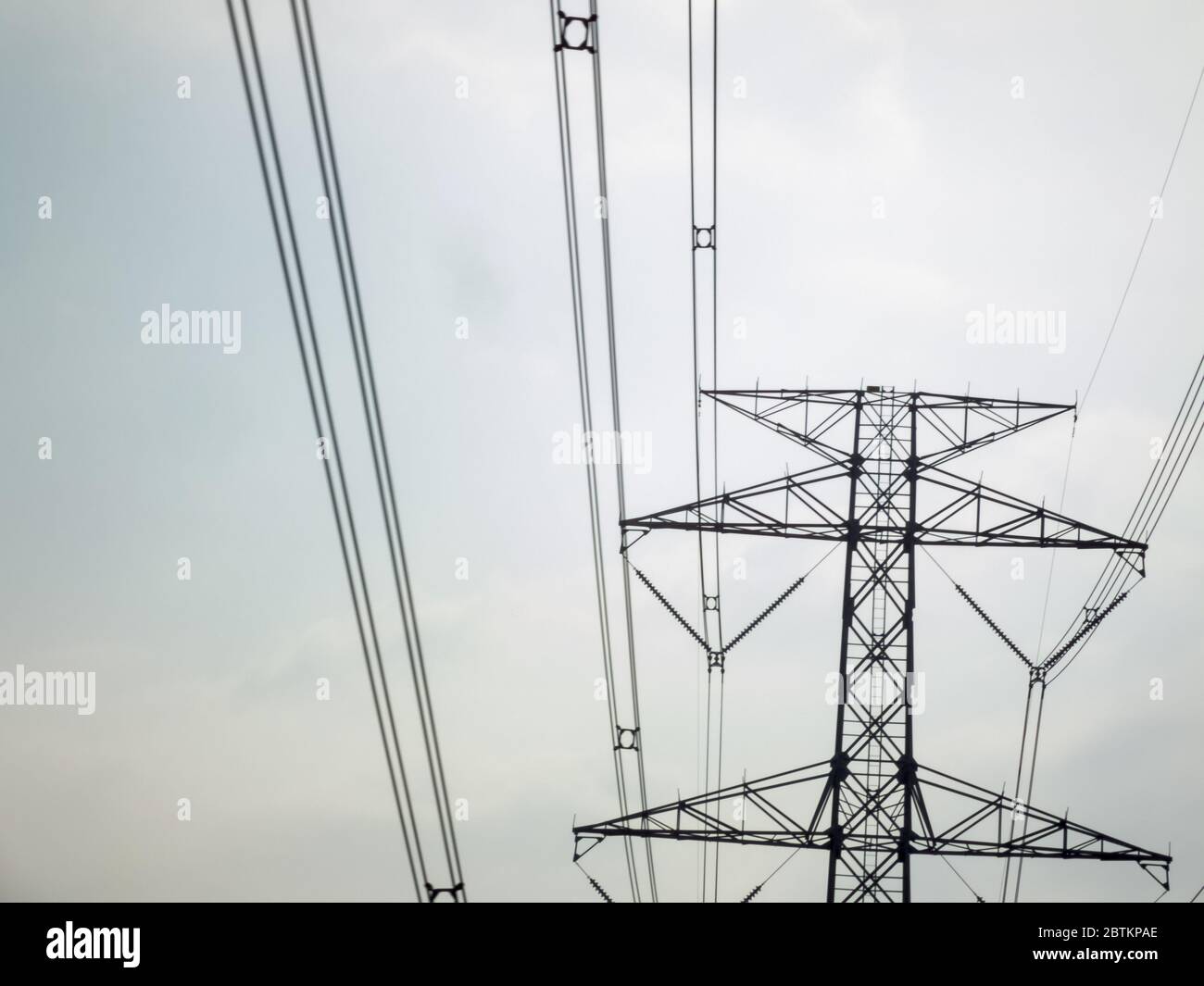 High-voltage pylons on a blue sky background Stock Photo - Alamy