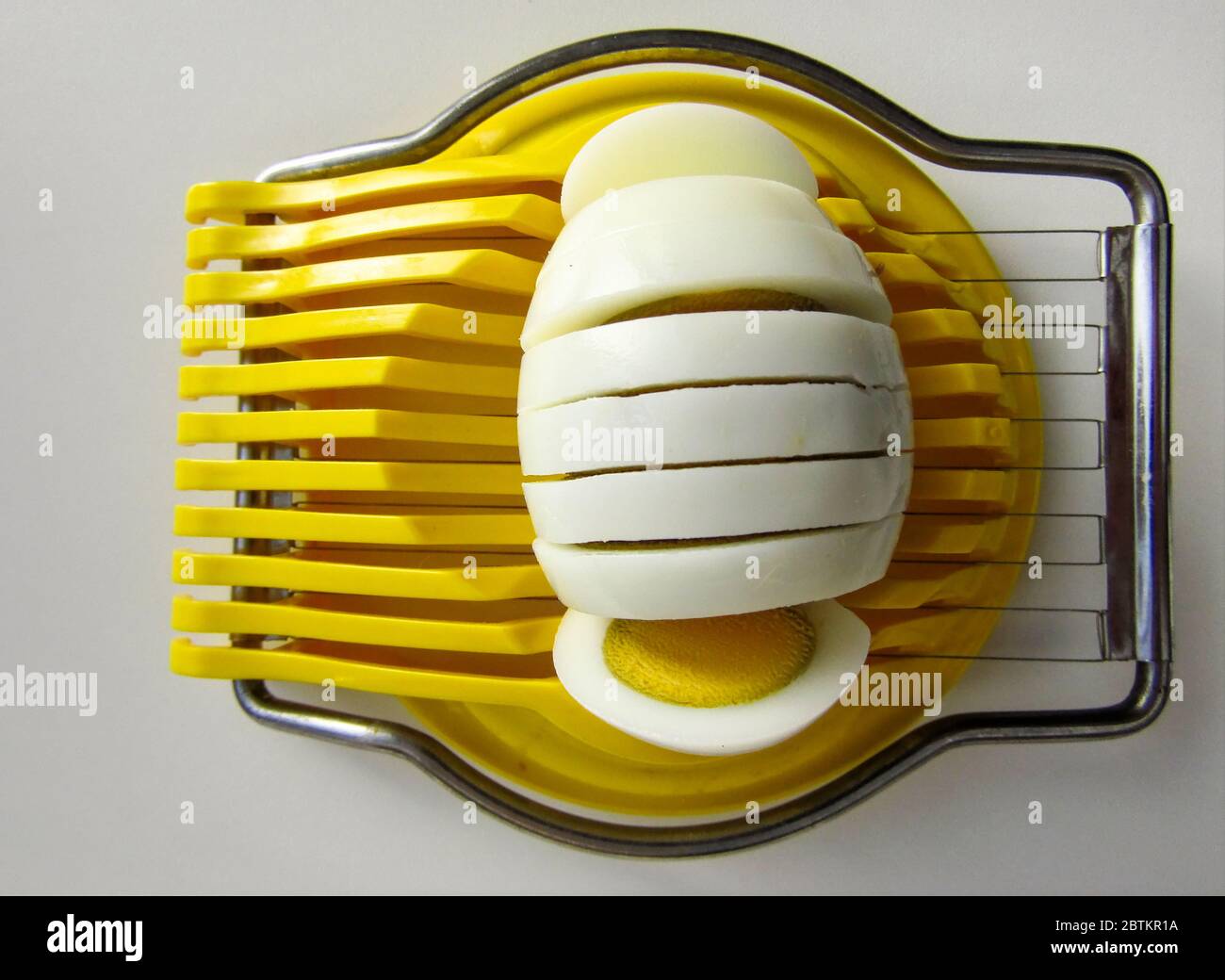 Hard-Boiled Egg in A Yellow Egg Slicer Stock Photo