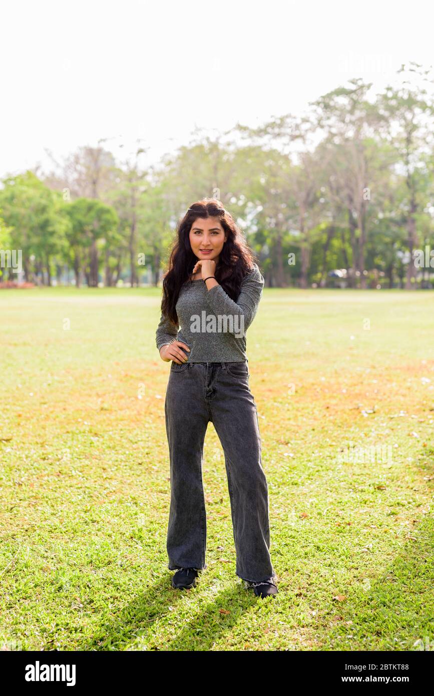 Full body shot of happy young beautiful Indian woman smiling at the ...