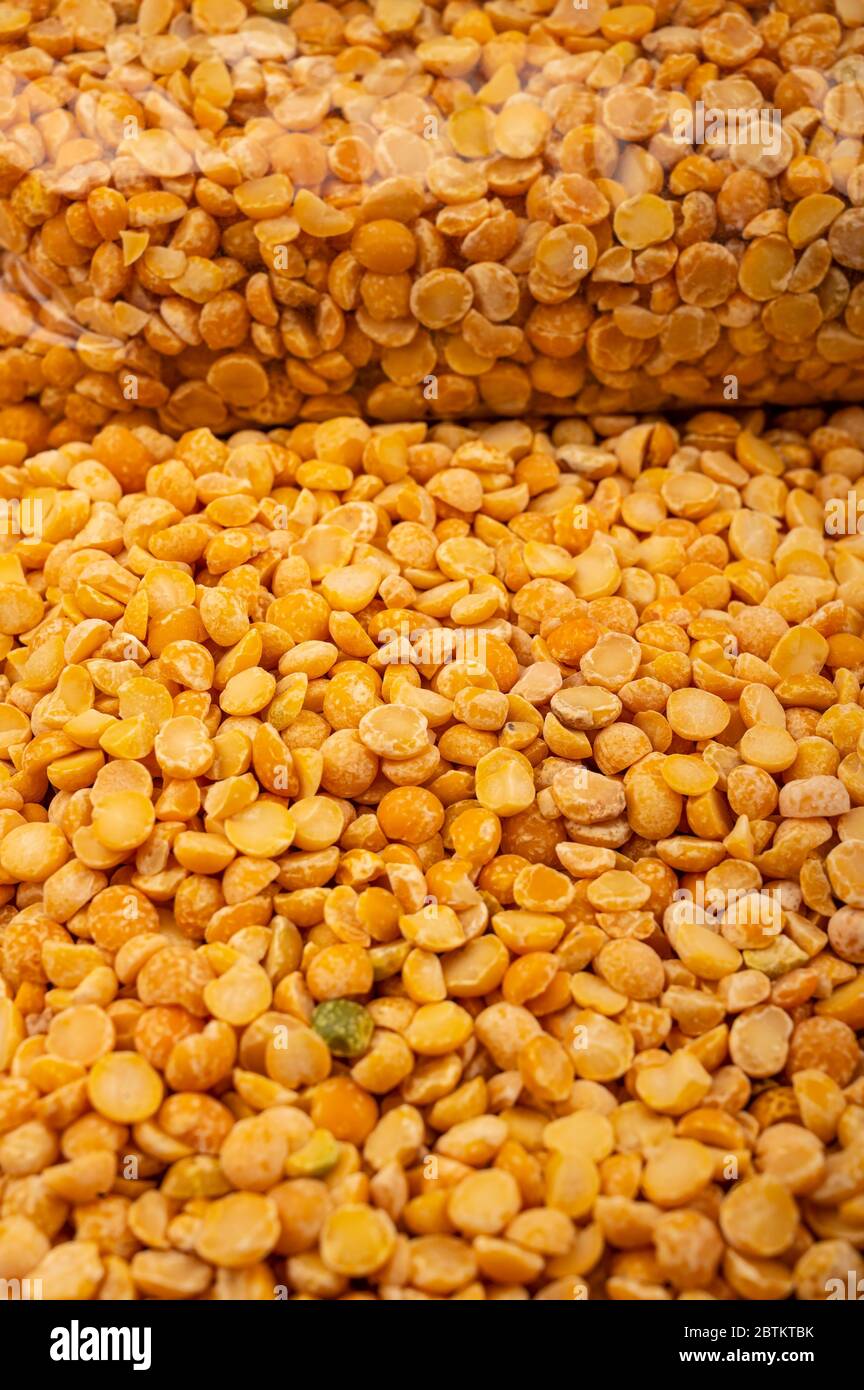 Yellow split peas in a plastic bag and cereal in bulk on a background of burlap with a rough