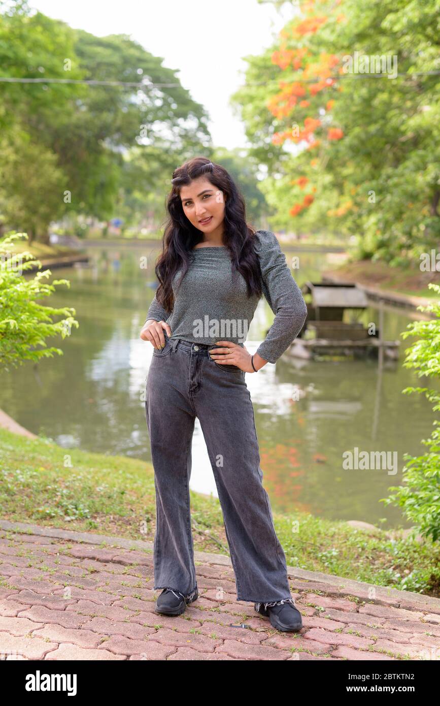 Full body shot of happy young beautiful Indian woman smiling at the ...