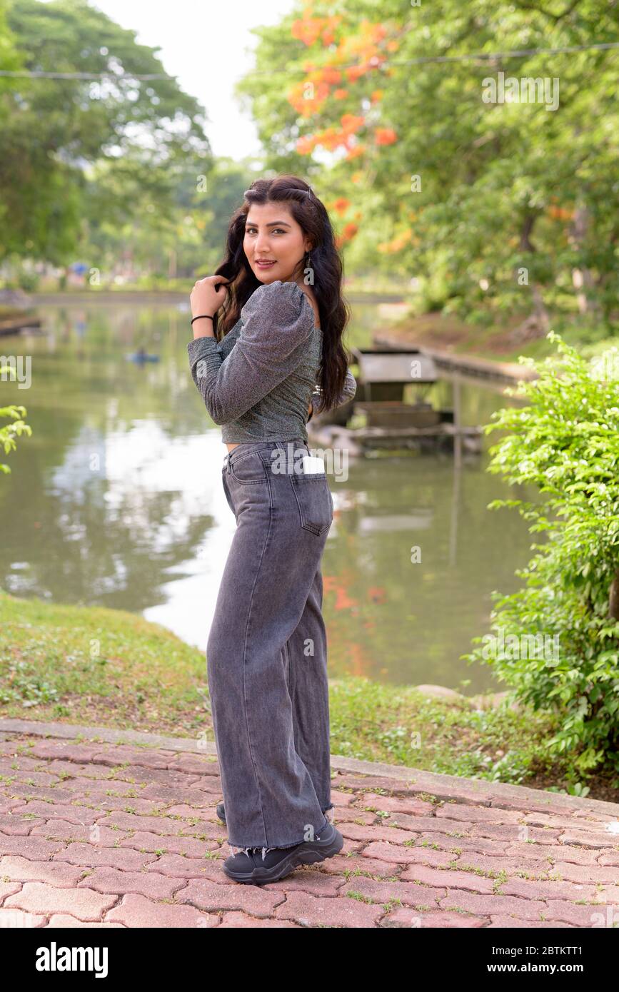 Full body shot of happy young beautiful Indian woman smiling at the ...