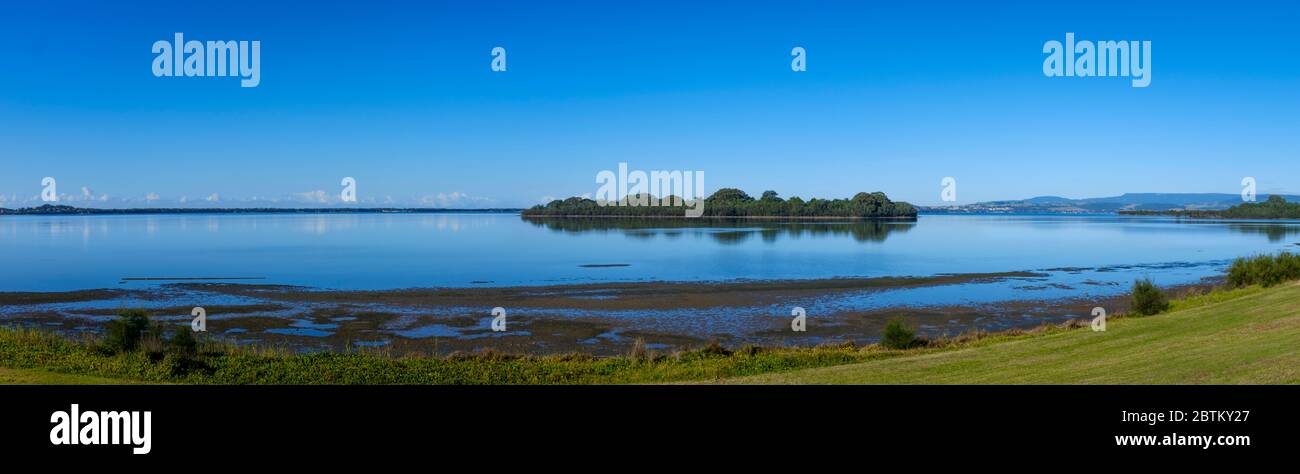 panoramic early morning view of island and reflections across Lake Illawarra, New South Wales, NSW, Australia Stock Photo