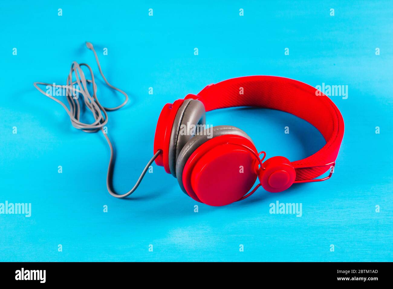Red headphones on blue background. Music concept Stock Photo