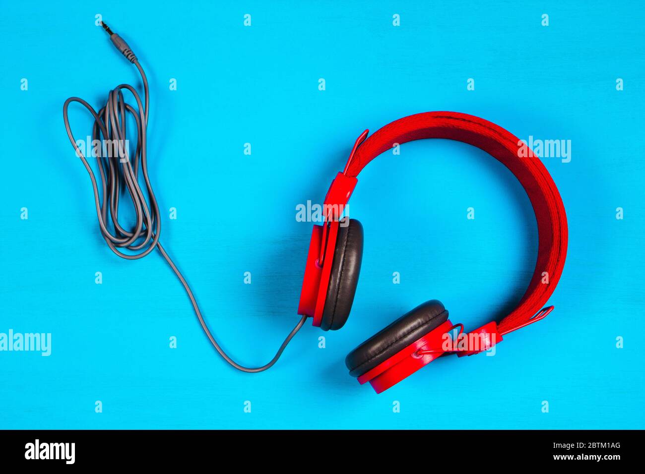 Red headphones on blue background. Music concept Stock Photo