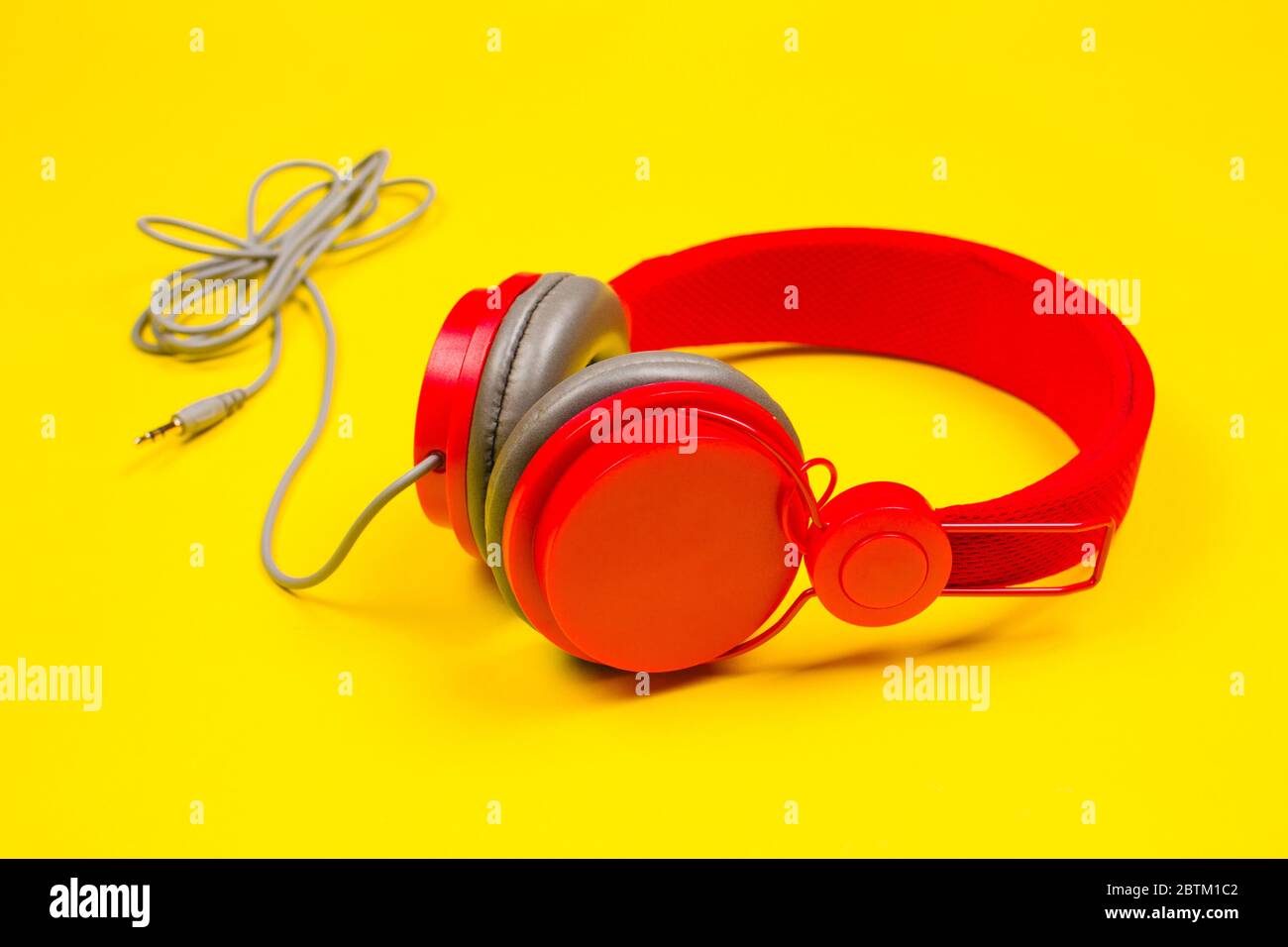 Red headphones on yellow background. Music concept Stock Photo