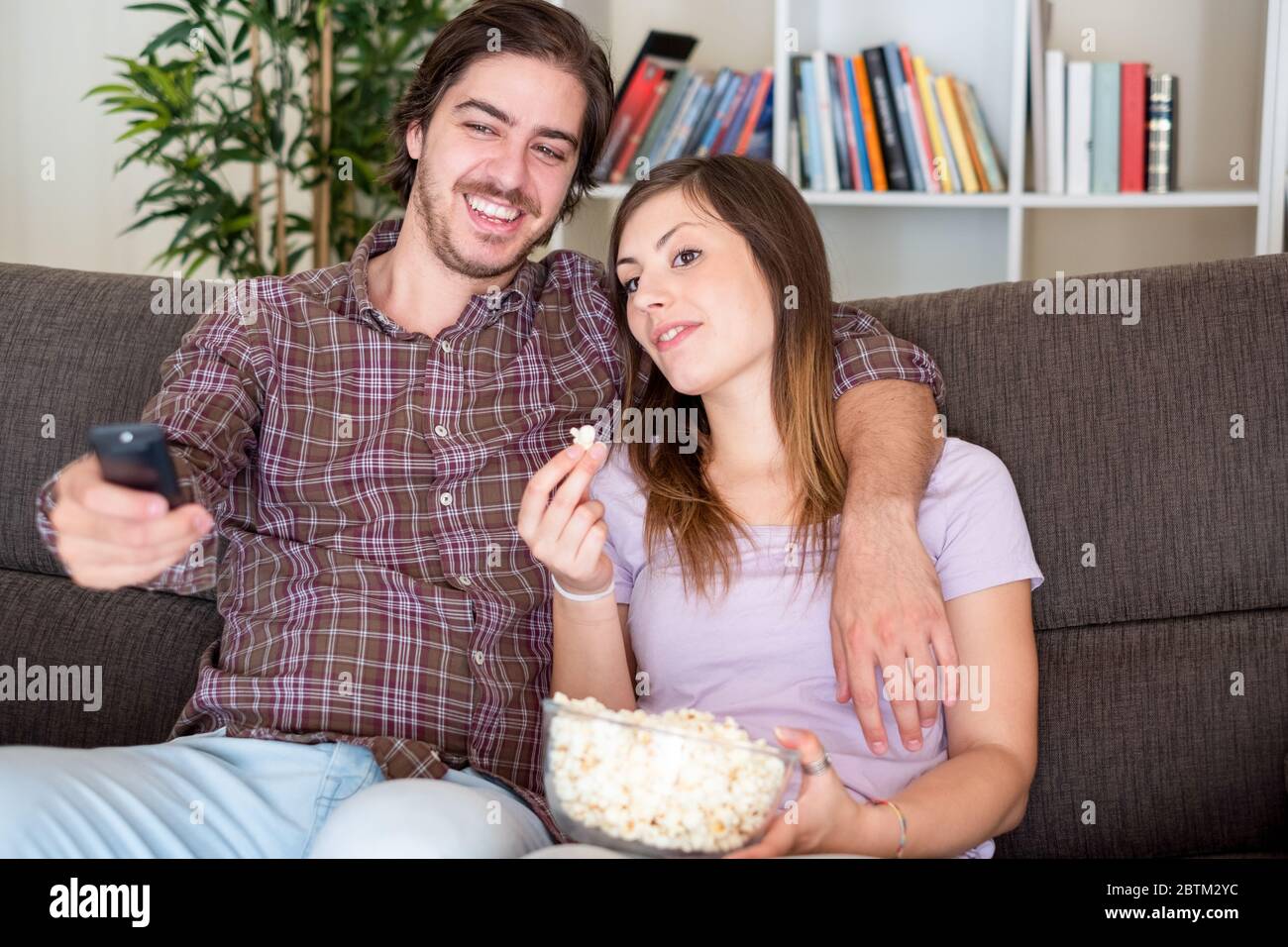 Happy young couple watching television at home Stock Photo