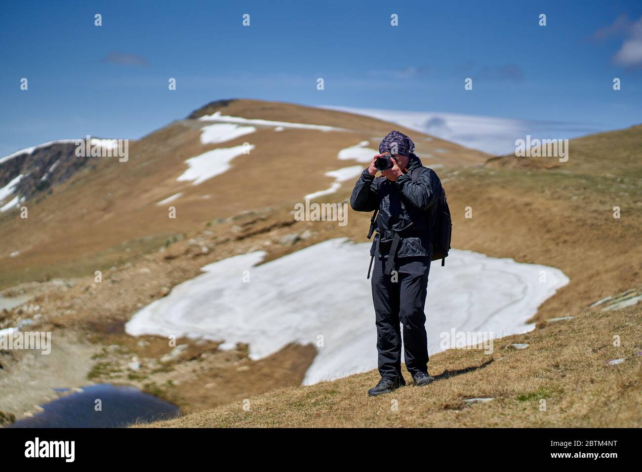 Tourist with camera hiking on a mountain trail Stock Photo - Alamy