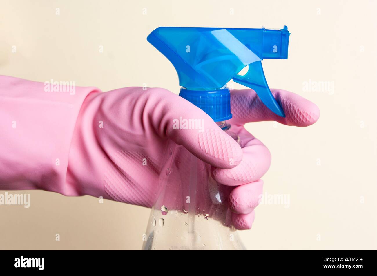 Hand in rubber glove holding spray bottle with detergent. Cleaning ...