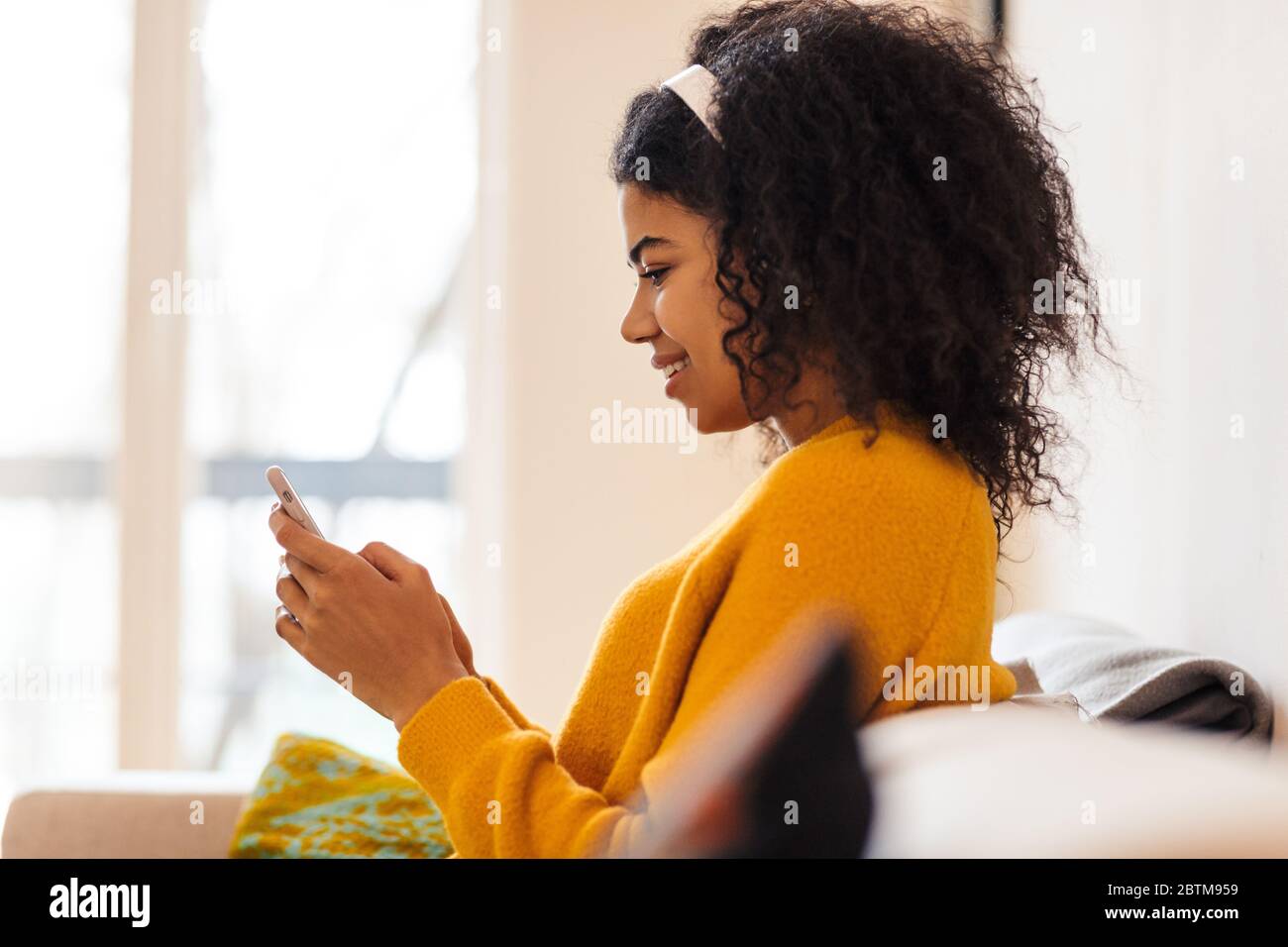 Image of joyful african american woman using headphones and cellphone ...