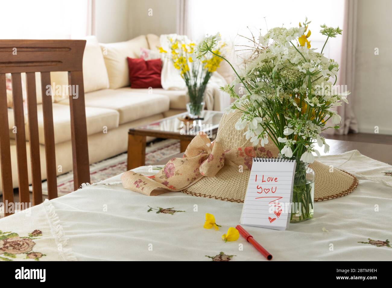 Cosy living interior with wild flowers bouquet and I love you note Stock Photo