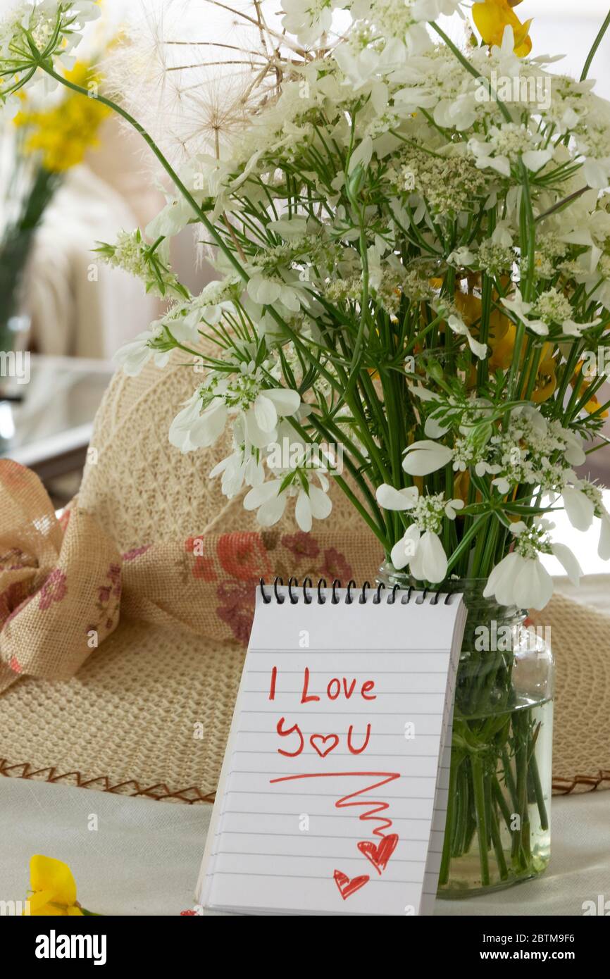 Cosy living interior with wild flowers bouquet and I love you note Stock Photo