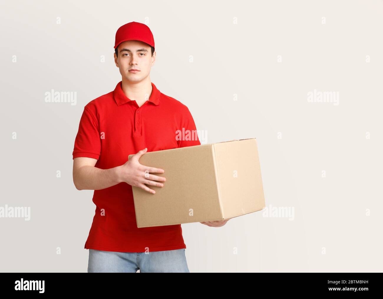 Work at post office. Courier holding big parcel Stock Photo Alamy