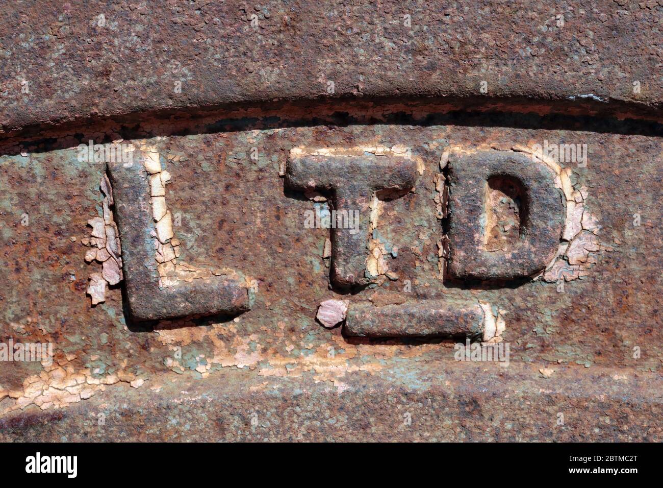 Letters LTD on the rusty surface of an old retro machineries. Its a limited company symbol, a class of company in several countries with limited liabi Stock Photo