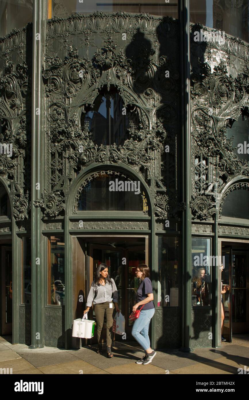 Sullivan Center northwest entrance with its cast-iron ornamental work and some girls going out of the store after shopping, Chicago, Illinois Stock Photo