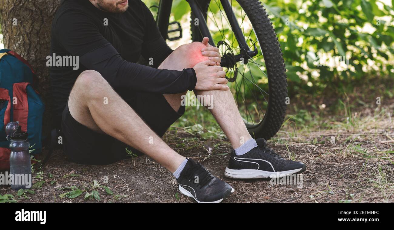 Young man having pain in his knee Stock Photo