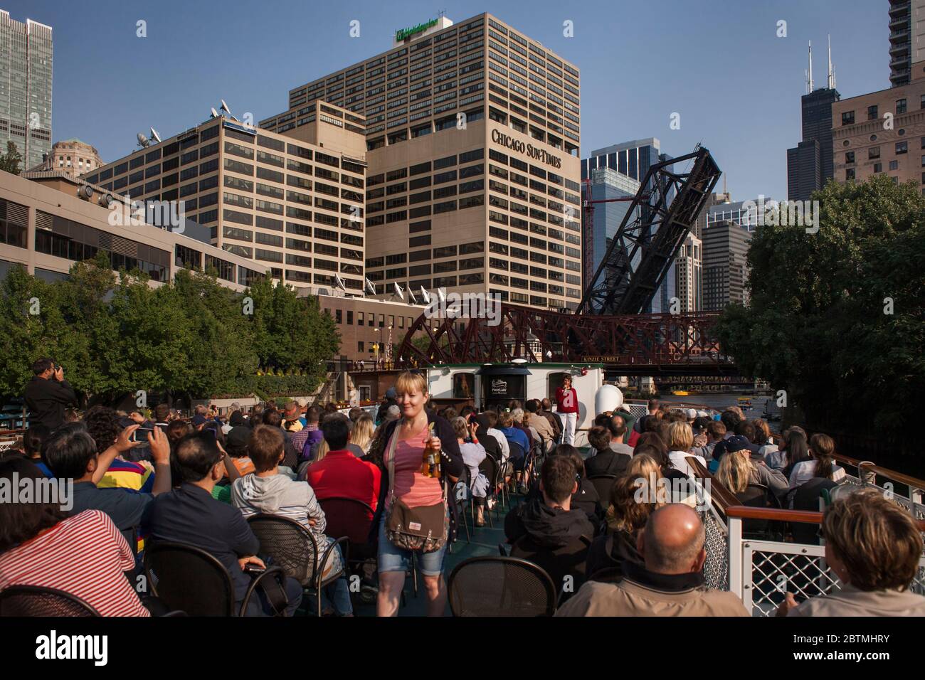 Horizontal view of the Kinzie Street Bridges, over the Chicago River, from an Architecture Cruise full of travelers on a sunny afternoon, Chicago Stock Photo