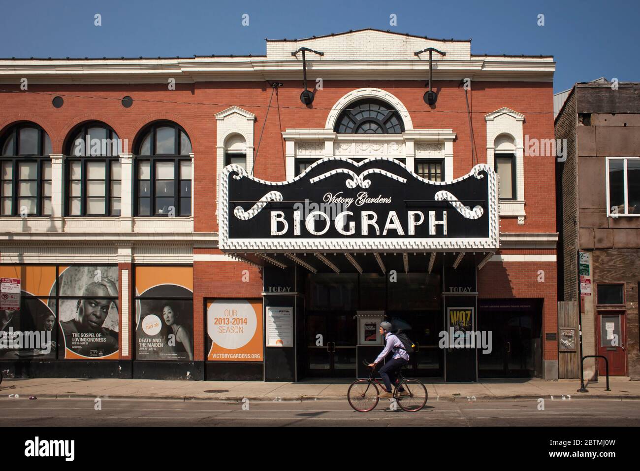 Horizontal view of a cyclist passing by the historic Biograph Theater (now Victory Gardens Theatre), where John Dillinger was killed, Chicago Stock Photo