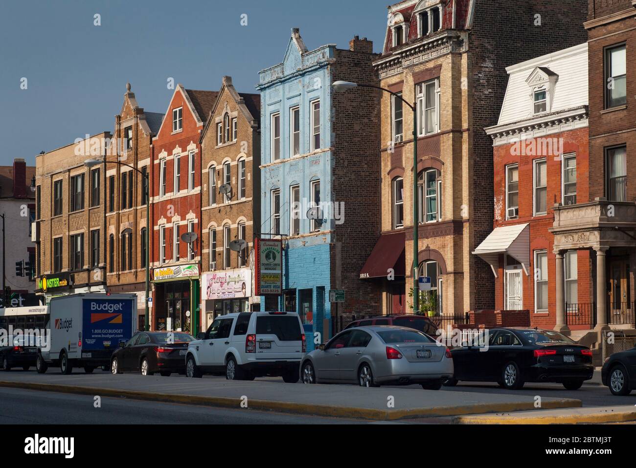 Horizontal shot of a colorful row of buildings illuminated by the sun