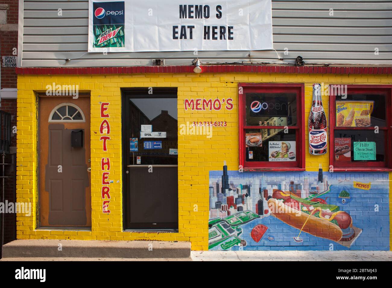 Horizontal shot of the colorful Memo’s Hot dogs fast food restaurant façade, Pilsen Historic District, Lower West Side community area, Chicago Stock Photo