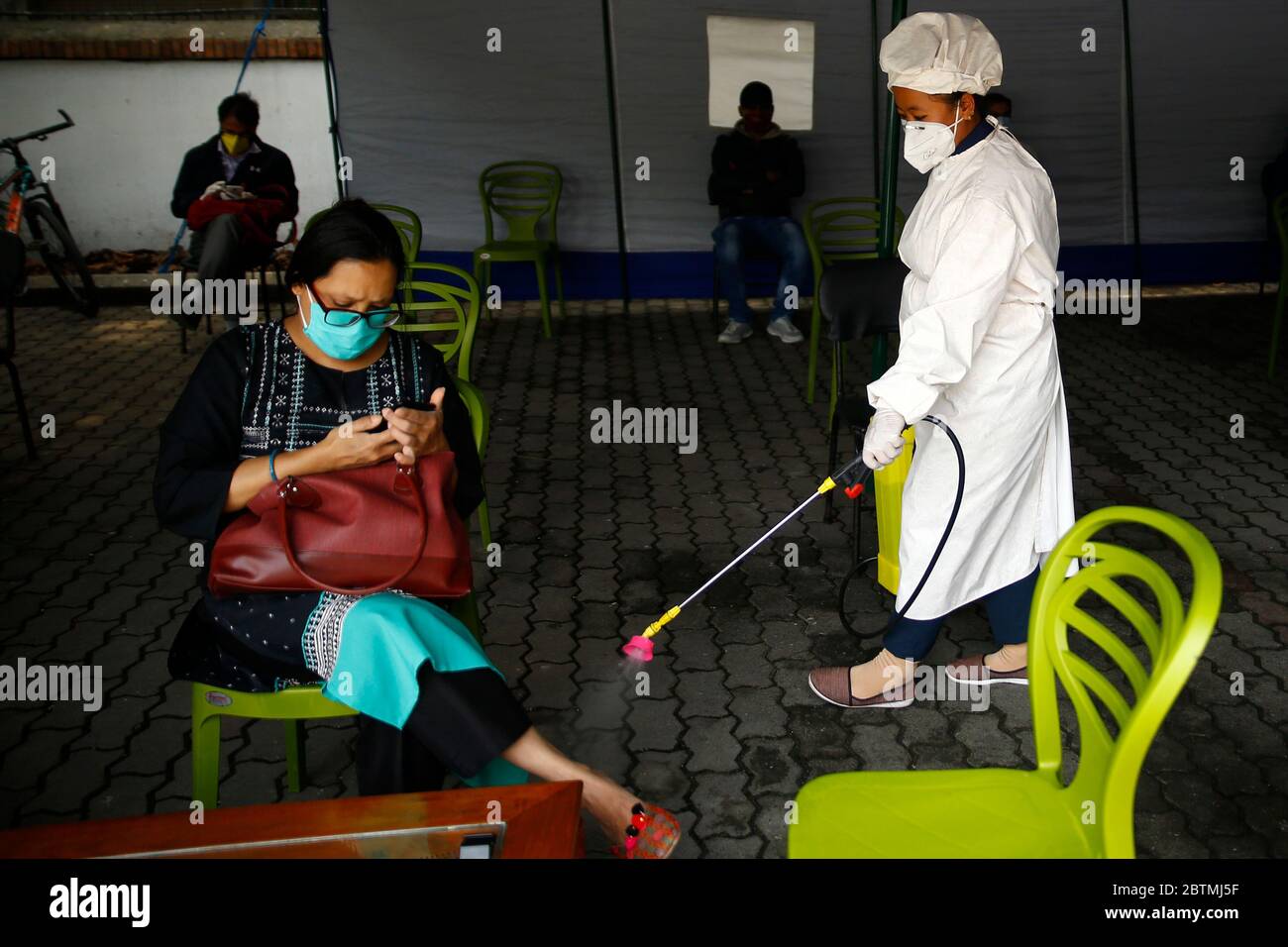 Kathmandu, Nepal. 27th May, 2020. A staffer disinfects the bank premise amid concerns over the spread of coronavirus disease during the government imposed lockdown at Nepal Investment Bank head office in Kathmandu, Nepal on Wednesday, May 27, 2020. Credit: Skanda Gautam/ZUMA Wire/Alamy Live News Stock Photo