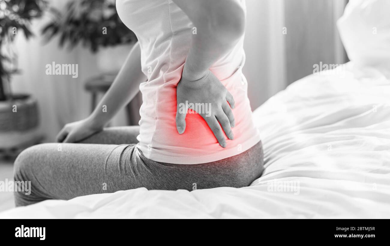Woman Having Back Ache Sitting On Bed Indoor, Cropped, BlackAndWhite