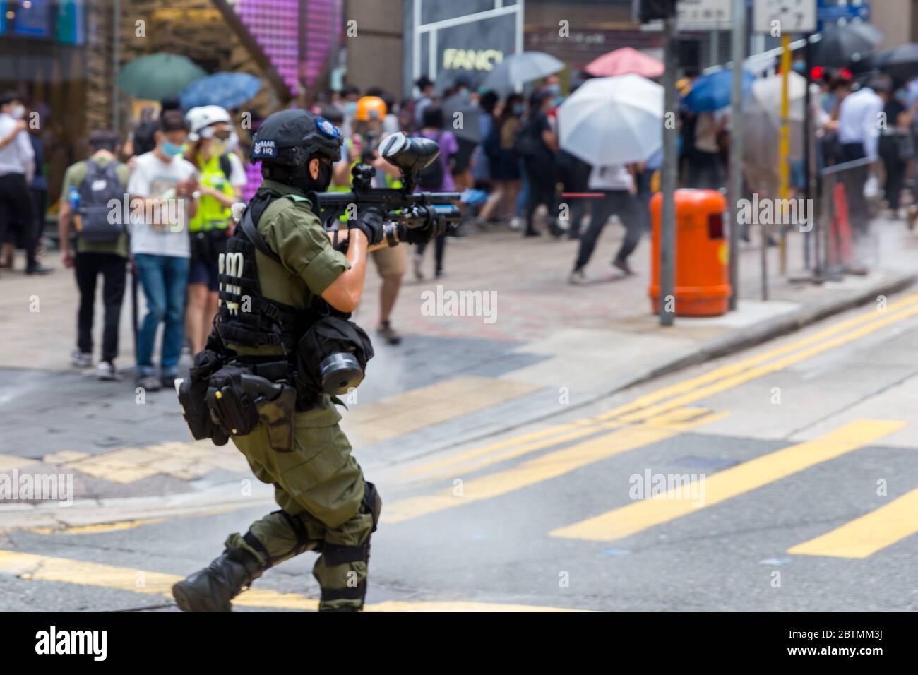 Central, Hong Kong. 27 May, 2020 Hong Kong Protest Anti-National Anthem Law. Female Police Officer fires pepper balls into the crowd. Credit: David Ogg / Alamy Live News Stock Photo