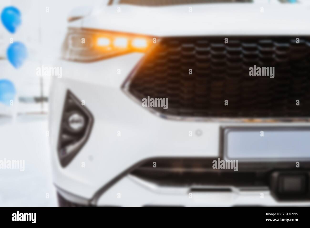 Abstract blur headlights and fog lights of a car for background. The car is white. Front view. Defocused. Stock Photo