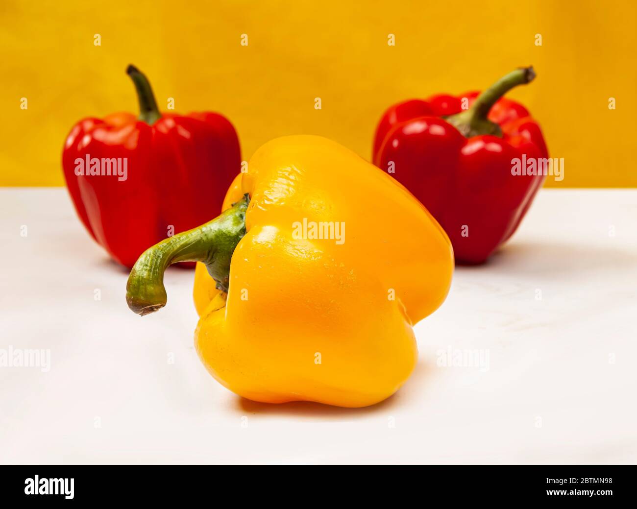 Composition of fresh harvest Bulgarian pepper on a yellow backround. Stock Photo
