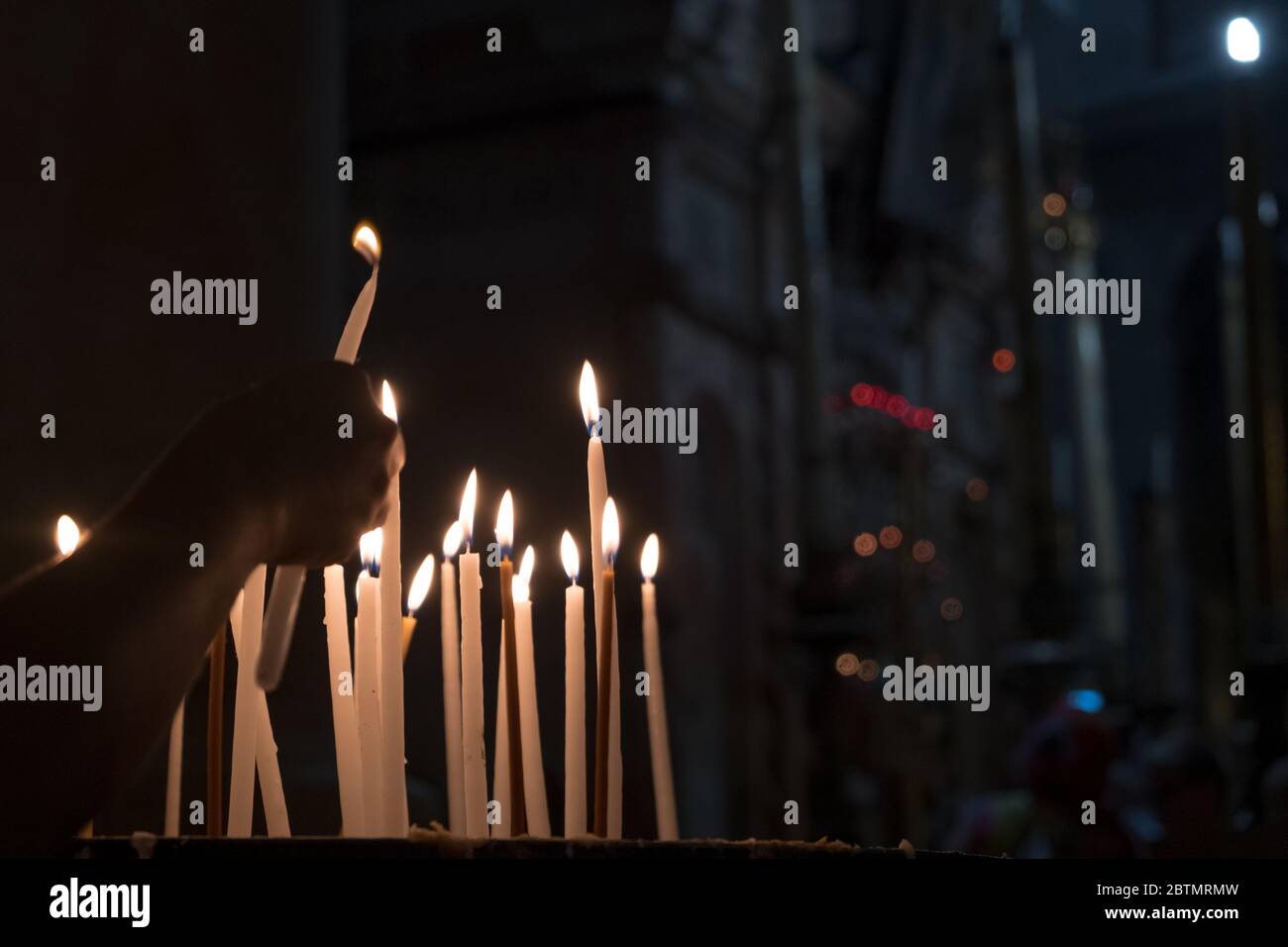 Worshippers lighting candles on the Stone of Annointing at the Chruch
