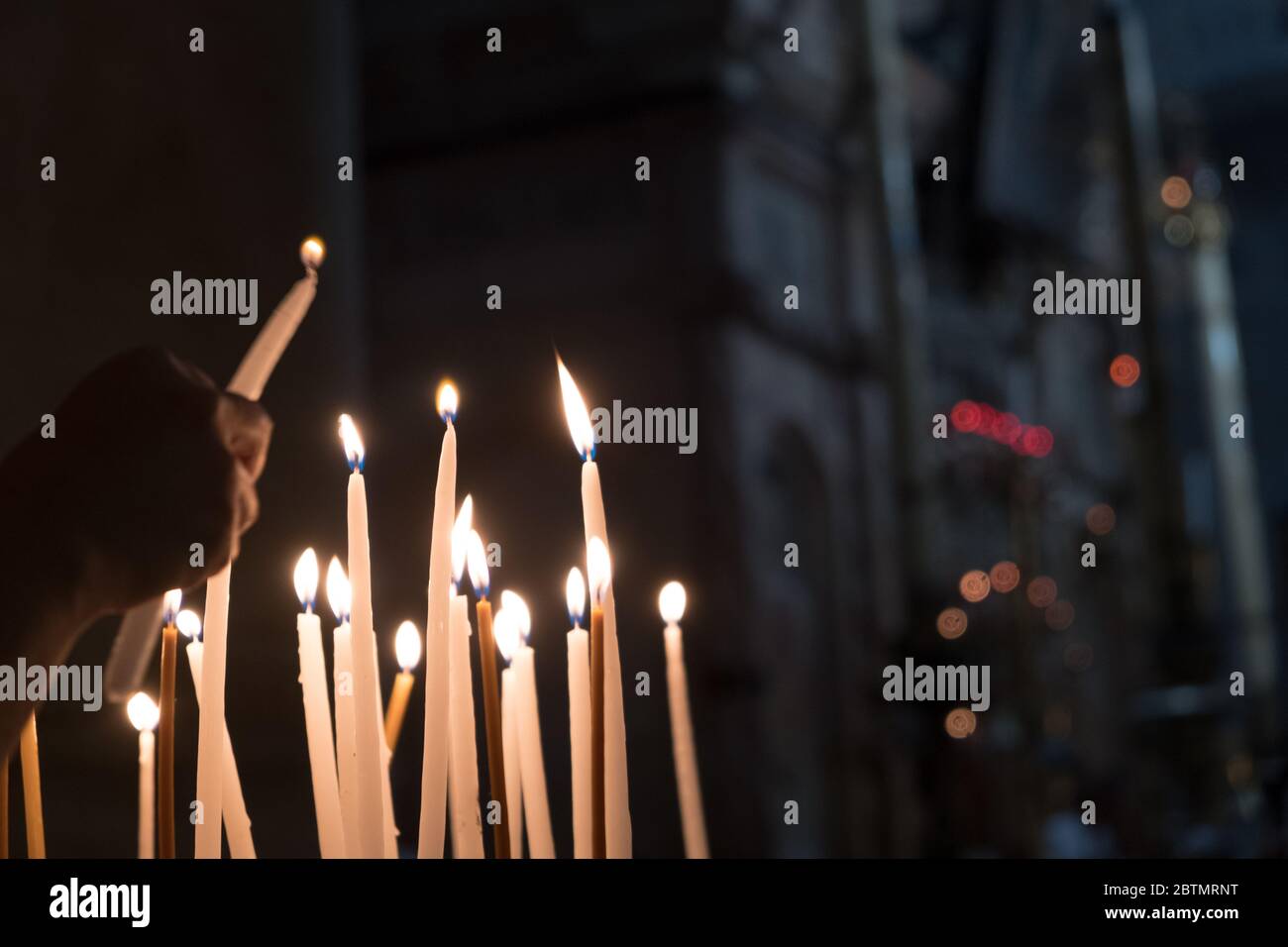 Worshippers lighting candles on the Stone of Annointing at the Chruch
