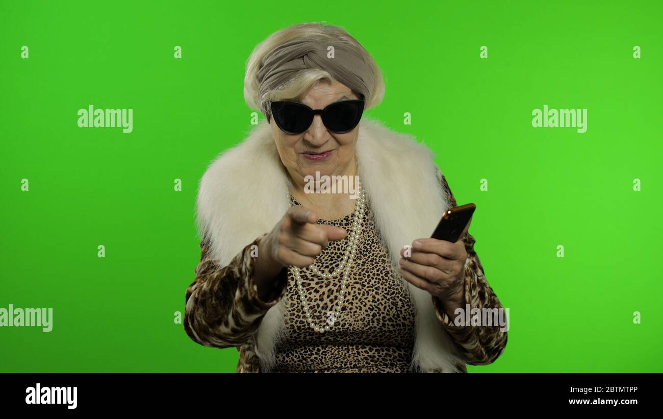 Elderly stylish granny caucasian mature woman using app on smartphone for  online shopping confused face expression. Chroma key background. Old  grandmother in fashion wearing browsing on mobile phone Stock Photo - Alamy