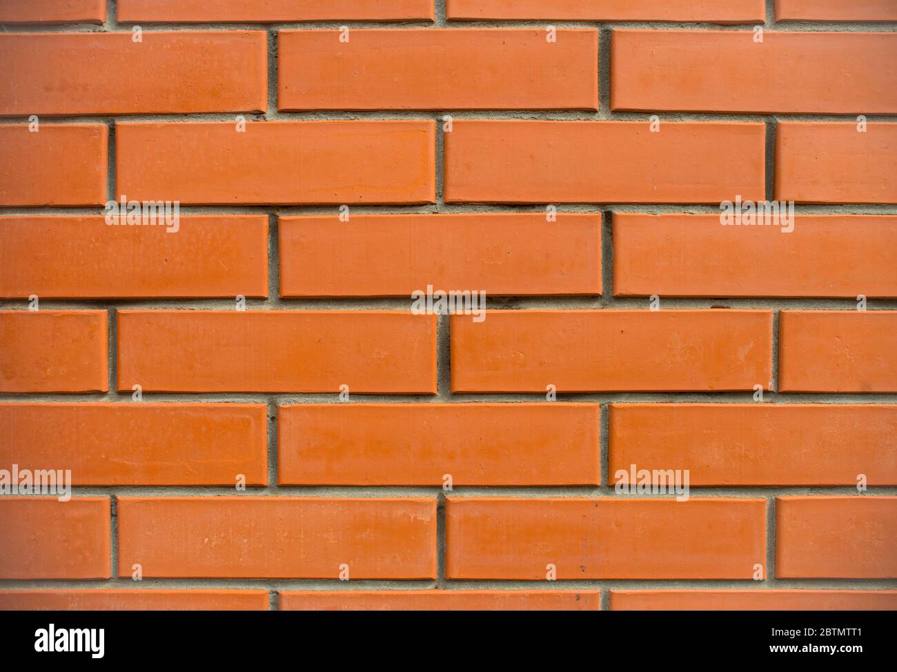 Orange bricks wall close up background. New built brick wall texture. Stock Photo