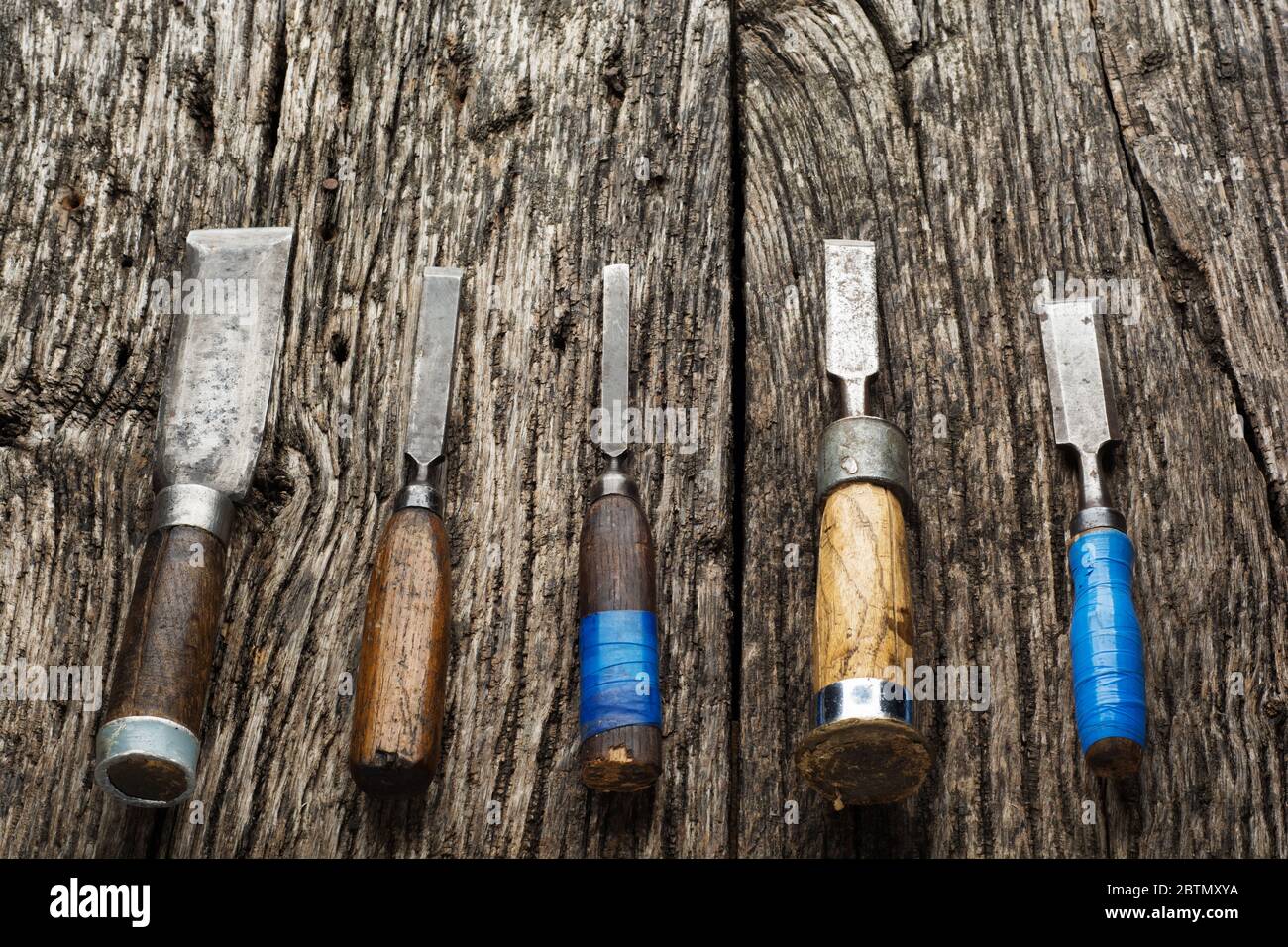 Carpenter tools composition. Old carpenter chisels laying on rustic wooden table upper view Stock Photo