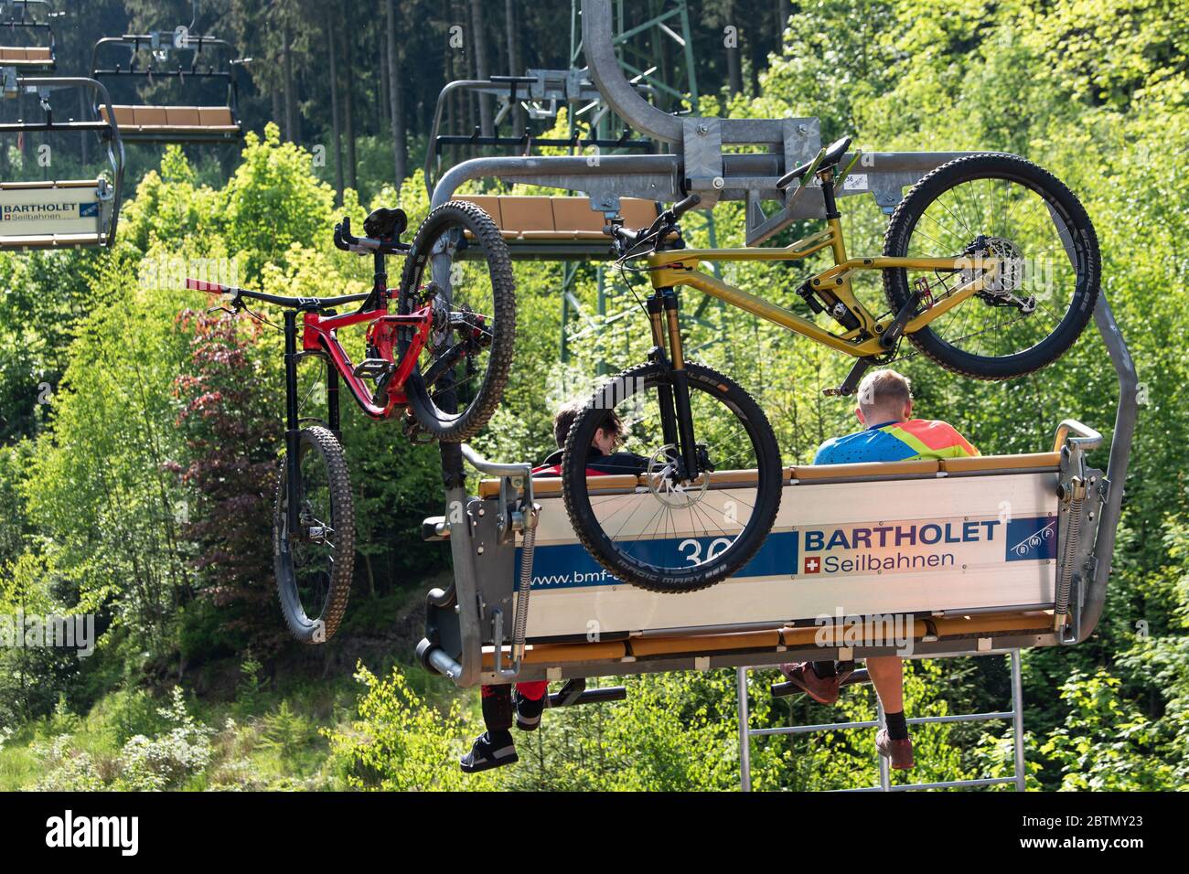 Goslar Hahnenklee, Germany. 27th May, 2020. Two cyclists are sitting with  their mountain bikes in the chairlift on the Bocksberg in the Harz  Mountains and are transported to the Hahnenklee Bikepark. Credit: