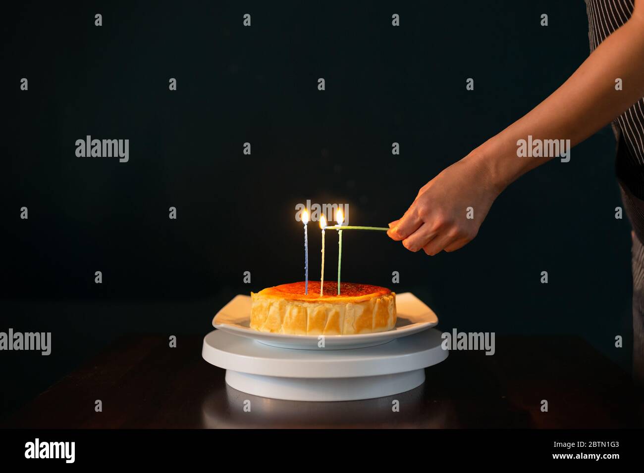 Hands lit candles on birthday cake isolated in black background Stock ...