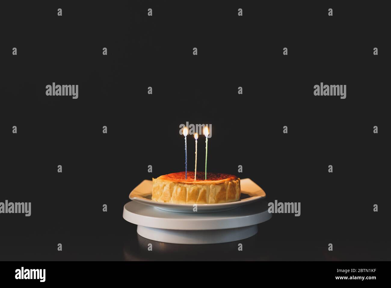 Birthday cake, lit candles isolated on black background Stock Photo - Alamy