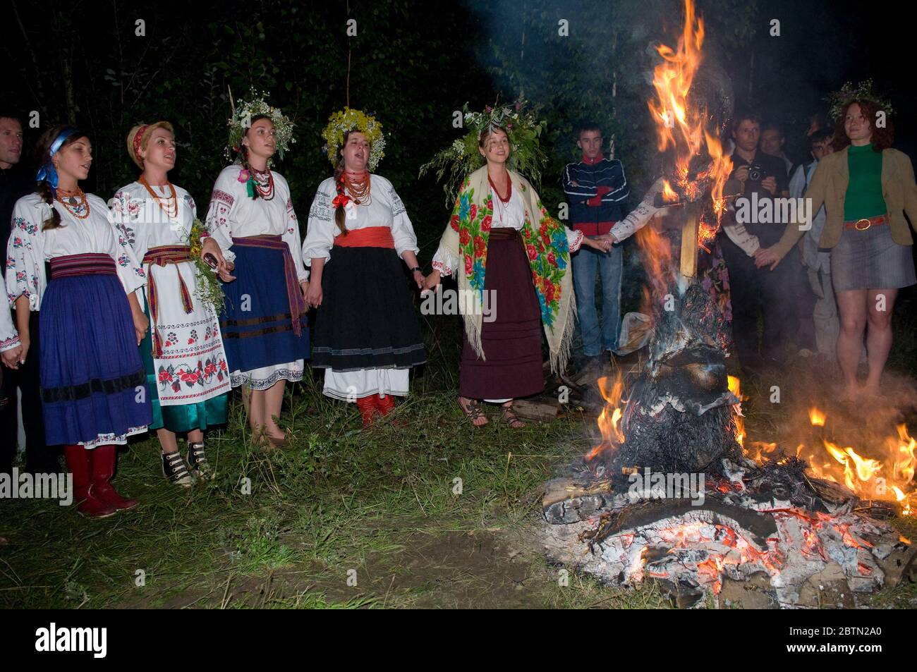 Kiev, Kievskaya Oblast/Ukraine - 07.06.2011. People in Ukrainian costumes sing songs. Ivan Kupala holiday night. Scene neare fire. Stock Photo