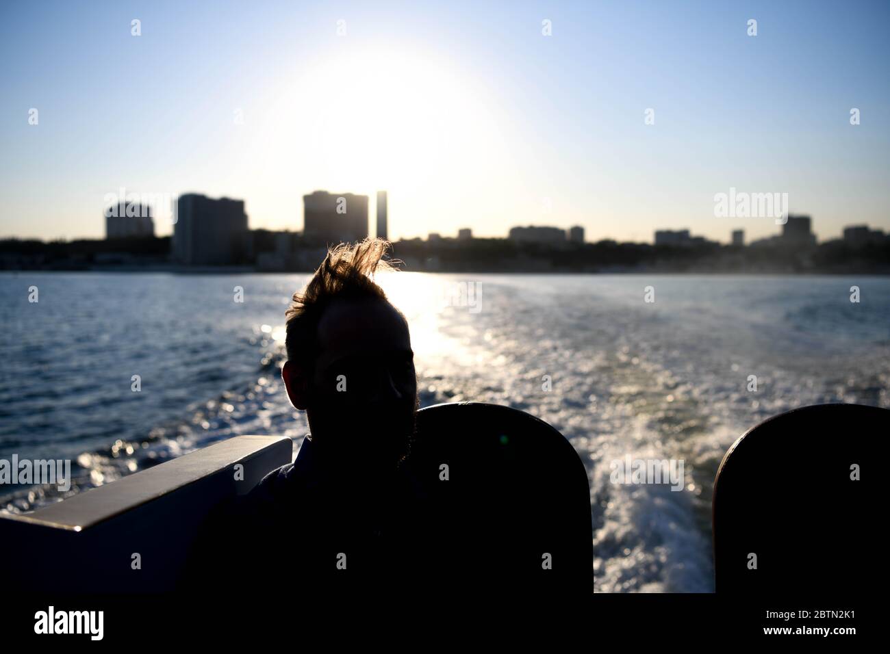 Europe, Ukraine, Odessa. Silhouette of a man against the light on a boat watching the port of Odessa. Stock Photo