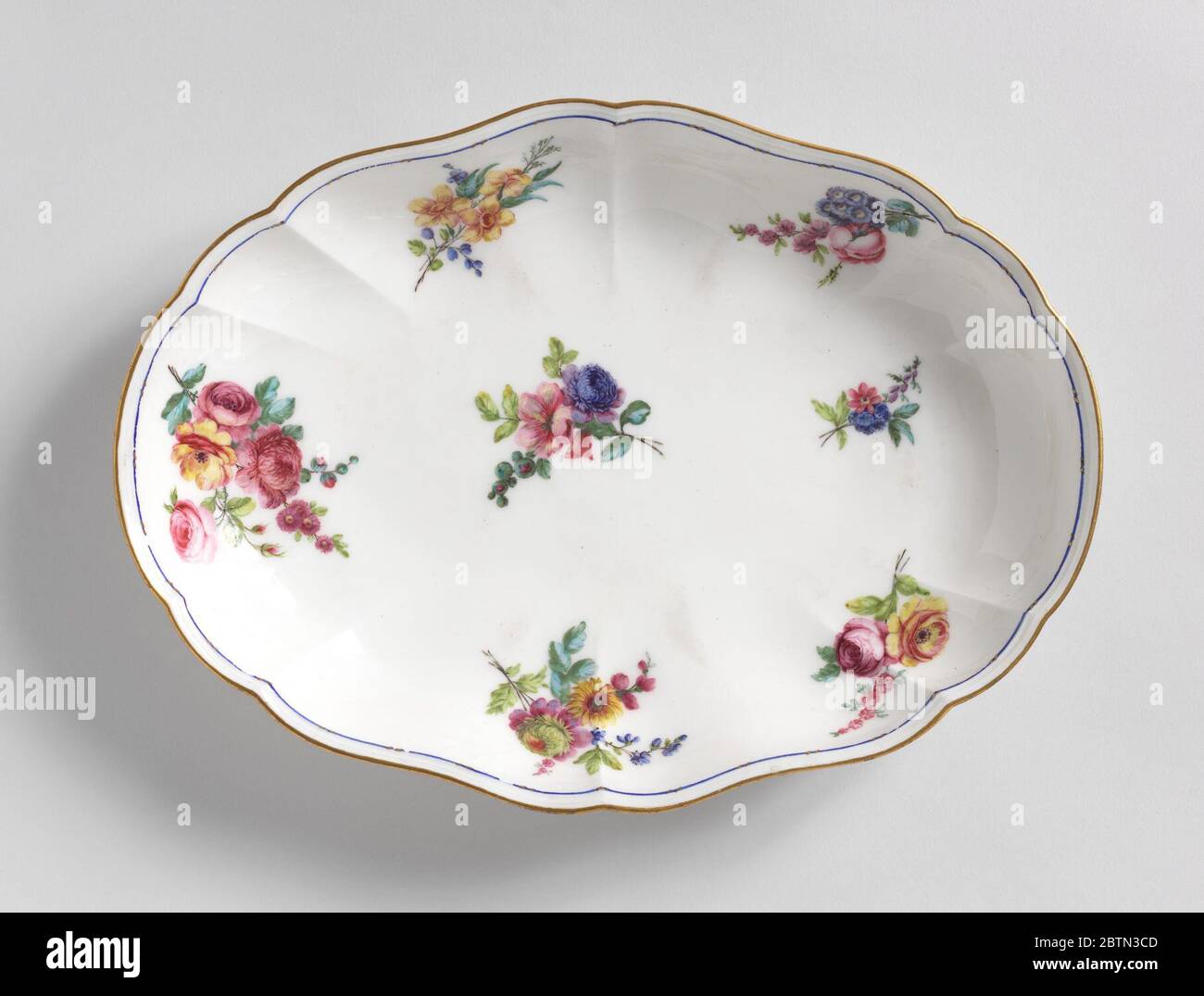 Oval Dishes with Floral Sprays. Research in ProgressOval slightly scalloped sides. Decorated with floral sprays. Slim blue band on inside edge. Top edge gilded. Stock Photo