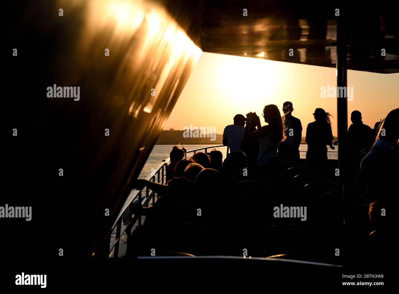 Europe, Ukraine, Odessa. Silhouette of tourists against the light on a boat watching the port of Odessa. Stock Photo