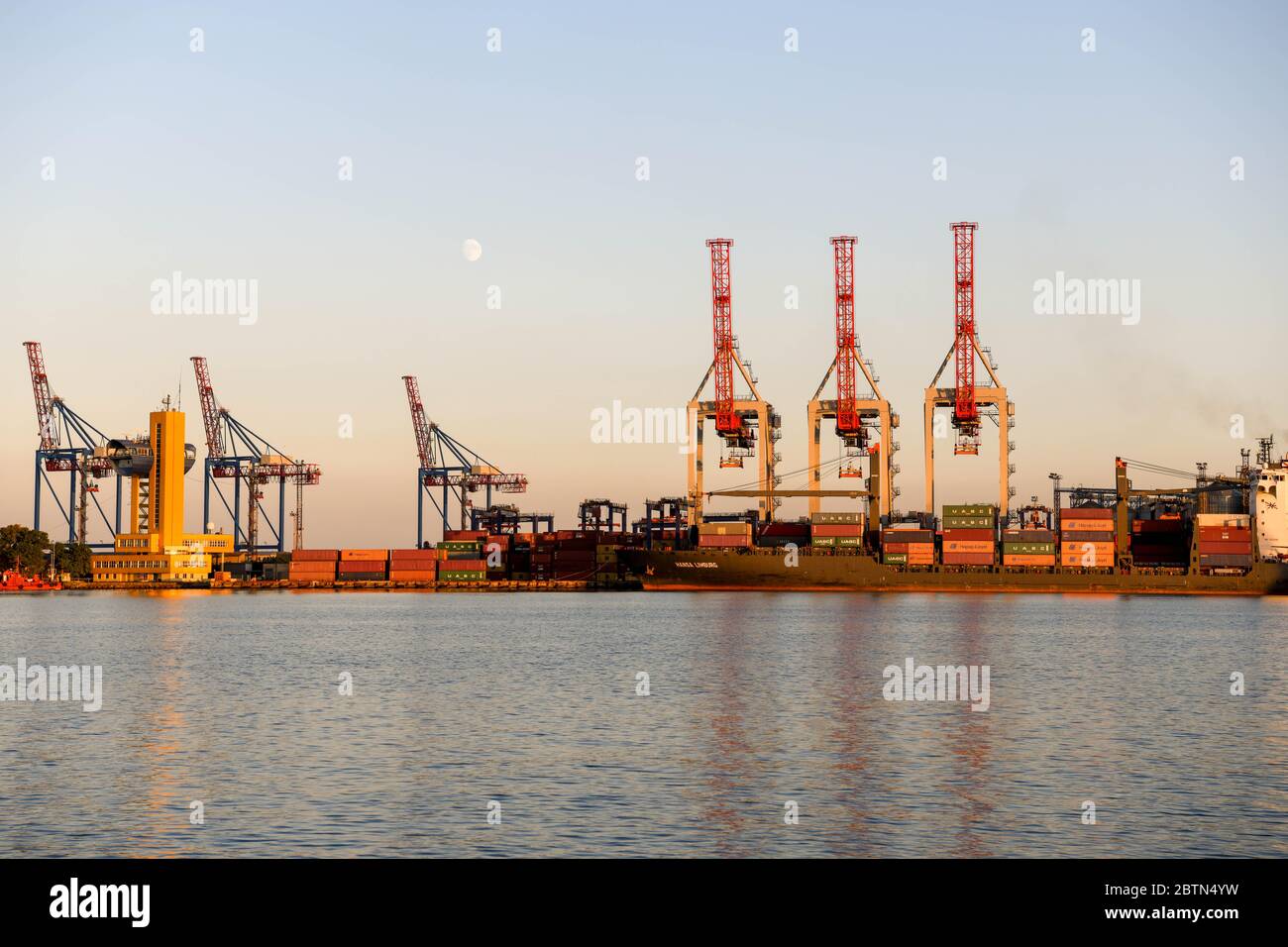 Europe, Ukraine, Odessa. The cranes in the port of Odessa at sunset with the moon in the background. Stock Photo