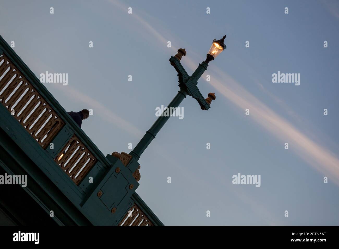 Illuminated traditional streetlamp at dusk on Southwark Bridge in London, England Stock Photo