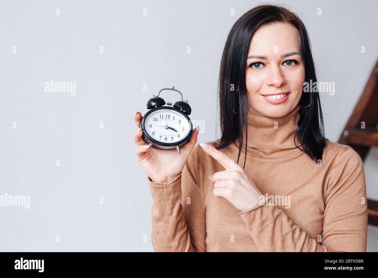 Час с девушками 18. Девушка с будильником в руках. будильник на руке. девушка смотрит время на часах.