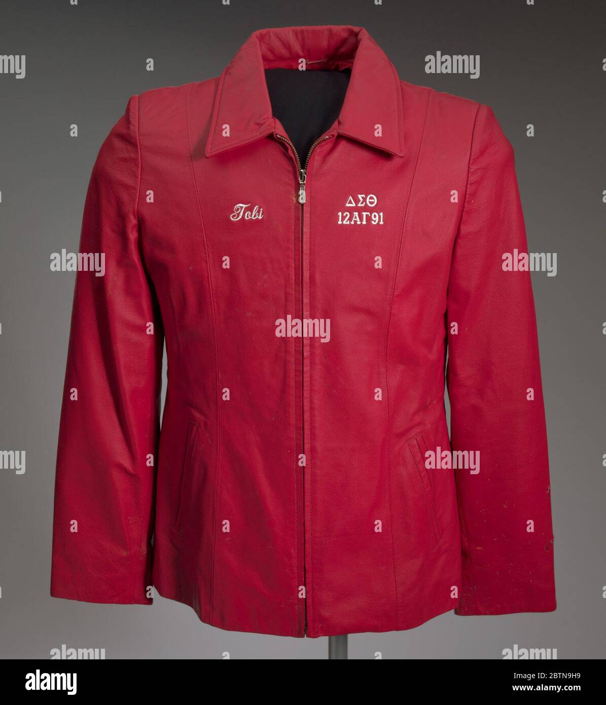 Red leather Delta Sigma Theta jacket owned by Tobi Douglas A Pulley. A red leather Delta Sigma Theta jacket owned and worn by Tobi Douglas A. Pulley. The jacket is constructed of dyed red leather shell and polyester lining. There s a large collar and a zipper down the front. There is white embroidered on the chest of the jacket. Stock Photo