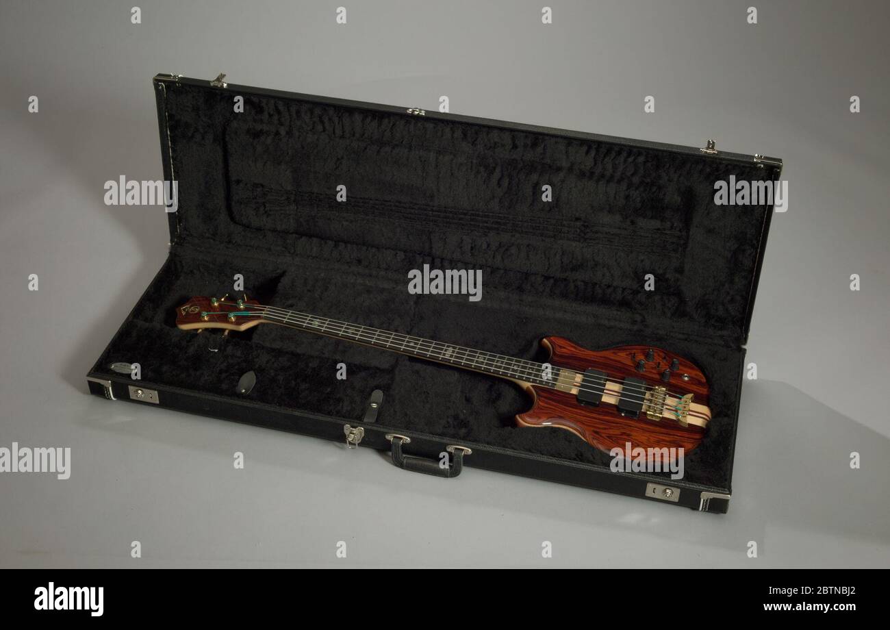 Instrument case owned by Stanely Clarke. Black vinyl case with metal clasp left of the handle. Two (2) locking clasps on either end of the top. Trimmed in white on outside. Interior lined with black fuzzy synthetic fabric and padded depressions where the bass rests. Compartment at the front left that snaps closed. Stock Photo