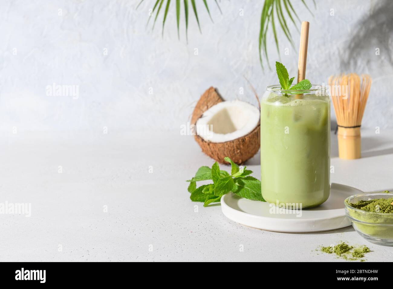 Premium Photo  Iced green tea matcha dalgona in two glasses with a straw  and a bowl of matcha powder for cooking on a wooden tray white background  space for text