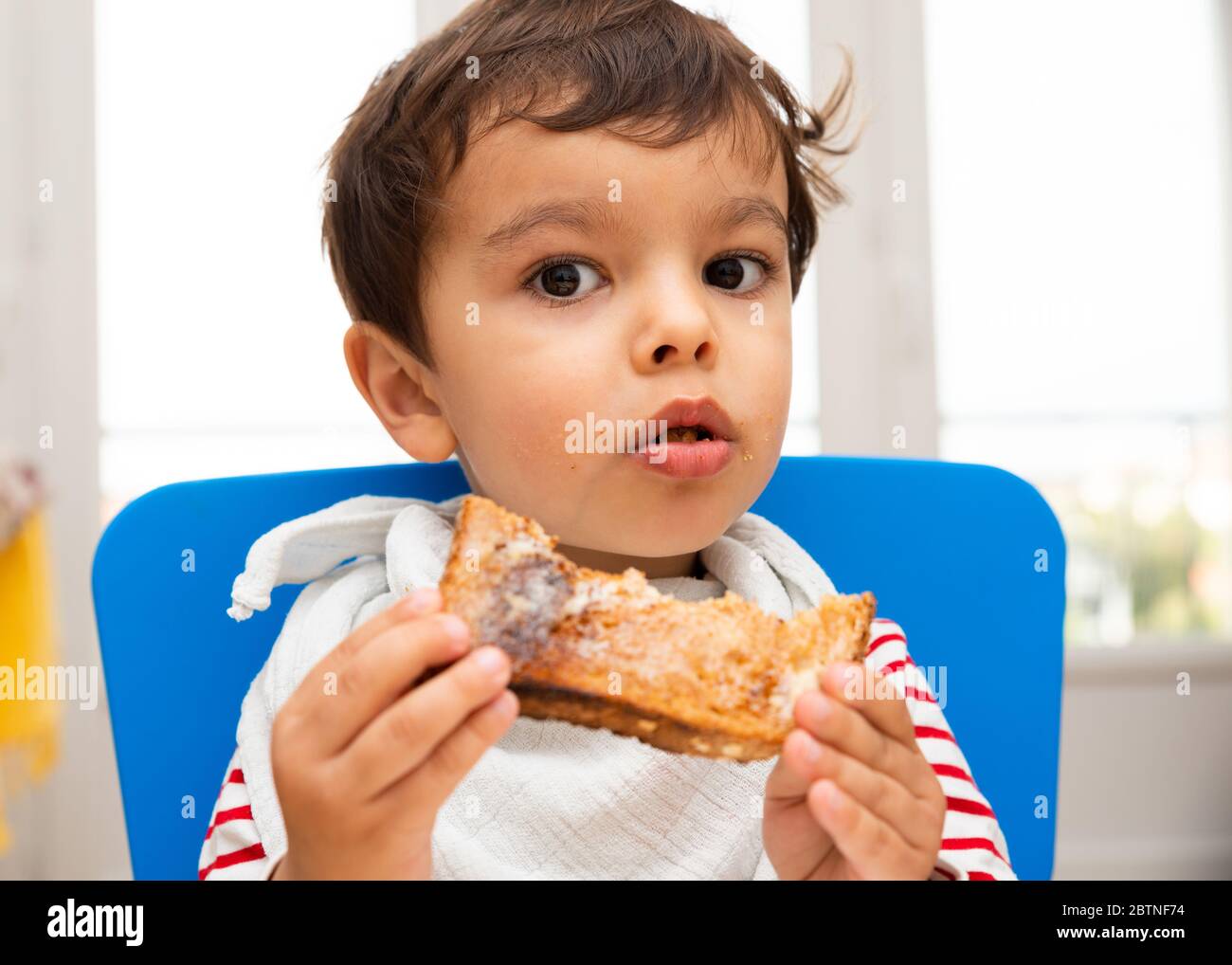 Toddler eating a toast Stock Photo Alamy